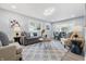 Open-concept living room features a gray couch and modern decor with lots of light from the large windows at 3334 N Chester Ave, Indianapolis, IN 46218