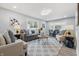 Open-concept living room features a gray couch and modern decor with lots of light from the large windows at 3334 N Chester Ave, Indianapolis, IN 46218