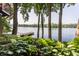Lush backyard garden with hosta plants and mature trees leading to a private lake dock at 3585 Bay Rd N Dr, Indianapolis, IN 46240