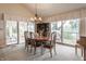 The formal dining room includes a view of the lake, a piano, and a beautiful chandelier at 3585 Bay Rd N Dr, Indianapolis, IN 46240