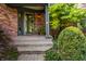 Inviting front entrance with brick steps, potted plants, and a decorative storm door at 3585 Bay Rd N Dr, Indianapolis, IN 46240