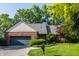 Charming brick home featuring an attached garage and a beautifully maintained lawn at 3585 Bay Rd N Dr, Indianapolis, IN 46240