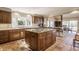 Open kitchen with island cooktop, tile floor, and eat-in bar seating at 3585 Bay Rd N Dr, Indianapolis, IN 46240