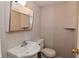 Small bathroom with toilet, sink, mirror, and wallpaper at 3668 Chatsbee Ct, Indianapolis, IN 46224