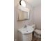 Small bathroom with toilet, sink, mirror, and wallpaper at 3668 Chatsbee Ct, Indianapolis, IN 46224