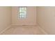 This is a small bedroom with a window, beige walls, and carpeted floors at 3668 Chatsbee Ct, Indianapolis, IN 46224