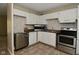 Bright kitchen features stainless steel appliances, white cabinetry, and durable floors at 3668 Chatsbee Ct, Indianapolis, IN 46224