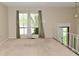 Bright living room featuring large windows, neutral walls, staircase, and carpet at 3668 Chatsbee Ct, Indianapolis, IN 46224