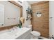 Rustic bathroom with wood accent wall, decorative mirror, and modern fixtures at 3713 W 98Th St, Carmel, IN 46032