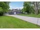 A long driveway leads to a beautiful blue home with green lawns and mature trees at 3713 W 98Th St, Carmel, IN 46032