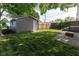 Backyard area featuring a detached garage, partial fencing, and a cozy fire pit area at 3822 Spann Ave, Indianapolis, IN 46203