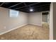 Finished basement with carpeting, painted walls, and a small window for natural light at 3822 Spann Ave, Indianapolis, IN 46203