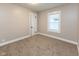Bedroom featuring neutral walls, carpet, bright window, and a white door at 3822 Spann Ave, Indianapolis, IN 46203