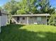 Backyard view of home with beige wood paneling and a black security door at 3908 Bertrand Rd, Indianapolis, IN 46222