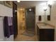 Well-lit bathroom featuring a glass-door shower, dark cabinetry, beige tile floor and neutral-toned walls at 4000 N Meridian St # Apt 11D, Indianapolis, IN 46208