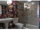 Bathroom showcases a pedestal sink, floral wallpaper and glass-enclosed shower at 4000 N Meridian St # Apt 11D, Indianapolis, IN 46208