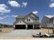 New construction home with stone accents and a two-car garage is bathed in sunlight at 4390 Red Pine Dr, Bargersville, IN 46106