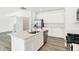 Bright, all-white kitchen featuring an island, stainless steel appliances, and wood-look flooring at 4390 Red Pine Dr, Bargersville, IN 46106