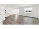 Bright living room with wood-look floors, two large windows, and an open concept layout, perfect for modern living at 4390 Red Pine Dr, Bargersville, IN 46106