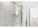 Shower with white marble tile, built-in shelf, and sleek glass door, creating a spa-like experience at 4390 Red Pine Dr, Bargersville, IN 46106