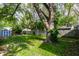 Lush backyard featuring a mature tree, green grass, shed, and a wooden fence at 4926 Crittenden Ave, Indianapolis, IN 46205