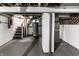 Unfinished basement with painted walls, exposed ceiling, and open staircase ready for customization at 4926 Crittenden Ave, Indianapolis, IN 46205