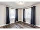 Bright bedroom with dark wood flooring, ample natural light, and tasteful blue curtains at 4926 Crittenden Ave, Indianapolis, IN 46205