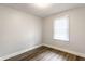 Cozy bedroom features a window, neutral walls, and dark wood-look flooring at 4926 Crittenden Ave, Indianapolis, IN 46205