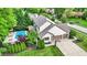 Aerial shot of a home and neighborhood with a pool, lush greenery, and multiple car garage at 5268 Woodfield Dr N, Carmel, IN 46033