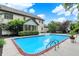 Backyard pool, patio, and seating area with surrounding landscaping and an enclosed sunroom at 5268 Woodfield Dr N, Carmel, IN 46033