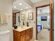 Bathroom with wood vanity and cabinets, mirror, and open access to an adjacent bedroom at 5268 Woodfield Dr N, Carmel, IN 46033