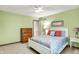 Bedroom featuring light green walls and a white wicker bed frame and side table at 5268 Woodfield Dr N, Carmel, IN 46033
