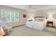 Cozy bedroom with neutral tones, plush carpet, rocking chair, and a comfortable bed with decorative pillows at 5268 Woodfield Dr N, Carmel, IN 46033