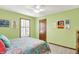 Bright bedroom with green walls, a ceiling fan, and a patterned bedspread at 5268 Woodfield Dr N, Carmel, IN 46033
