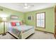 Bedroom with green walls and a queen bed with floral quilt cover at 5268 Woodfield Dr N, Carmel, IN 46033