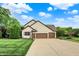 Traditional two-story home with a three-car garage, basketball hoop, and well-manicured lawn at 5268 Woodfield Dr N, Carmel, IN 46033