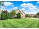Beautiful home with a manicured lawn, mature trees, and long driveway at 5268 Woodfield Dr N, Carmel, IN 46033