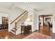 Elegant foyer featuring hardwood floors, staircase with white risers, and decorative console table at 5268 Woodfield Dr N, Carmel, IN 46033