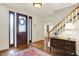 Inviting foyer featuring hardwood floors, a staircase, decorative front door, and a classic console table at 5268 Woodfield Dr N, Carmel, IN 46033
