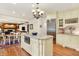 Bright kitchen features an island with granite countertops, stainless steel appliances, and views to an eat-in area at 5268 Woodfield Dr N, Carmel, IN 46033