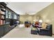Inviting living room featuring large windows, black leather furniture, and neutral carpet at 5268 Woodfield Dr N, Carmel, IN 46033