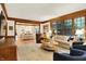 Bright living room with wood trim and hardwood floors, connecting to the kitchen at 5268 Woodfield Dr N, Carmel, IN 46033