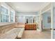 This light-filled bathroom has a large soaking tub, tiled flooring, and access to the main bedroom at 5268 Woodfield Dr N, Carmel, IN 46033