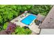 Aerial shot of the backyard pool and patio area surrounded by lush greenery and mature trees at 5268 Woodfield Dr N, Carmel, IN 46033