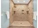 This stylish shower has beautiful tilework, glass doors, and dual shower heads and shelving at 5268 Woodfield Dr N, Carmel, IN 46033