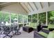 Cozy screened-in porch featuring comfortable wicker seating and an outdoor dining set at 5268 Woodfield Dr N, Carmel, IN 46033