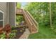 Two-story deck with wooden stairs and a cozy seating area overlooking the landscaped backyard at 527 Macintosh Ln, Danville, IN 46122