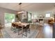 Open-concept dining area with modern lighting, a wood table, and access to the outdoor deck at 527 Macintosh Ln, Danville, IN 46122