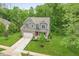 Well-manicured front yard with a two-story brick and gray siding home featuring an attached garage and covered porch at 527 Macintosh Ln, Danville, IN 46122