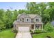 Charming two-story home featuring a brick facade, attached garage, and covered front porch with seating area at 527 Macintosh Ln, Danville, IN 46122